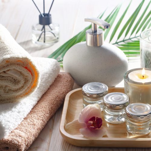 Spa and wellness setting with towels, candles and orchids